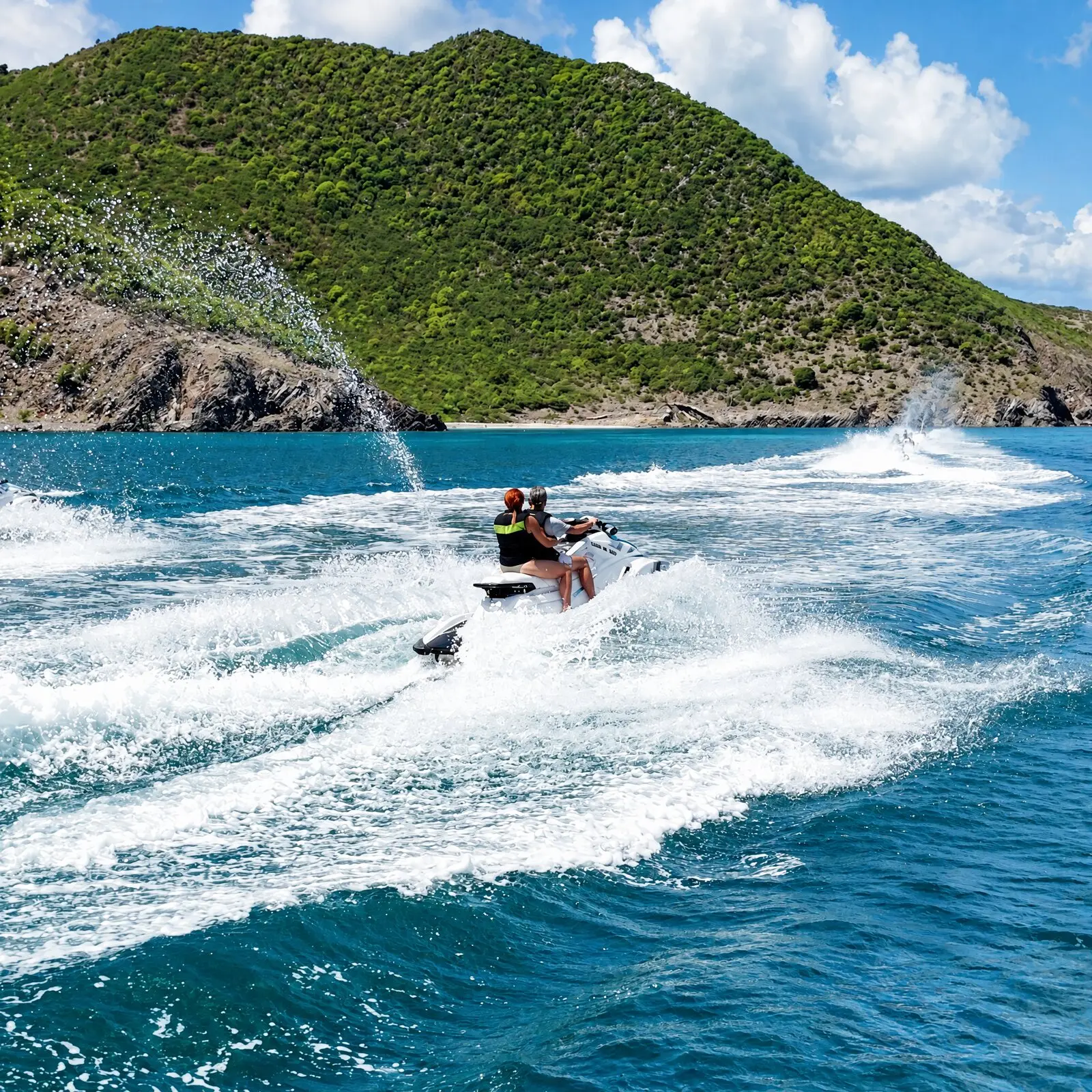 Des jet skis filent dans l'écume au pied d'une colline verte